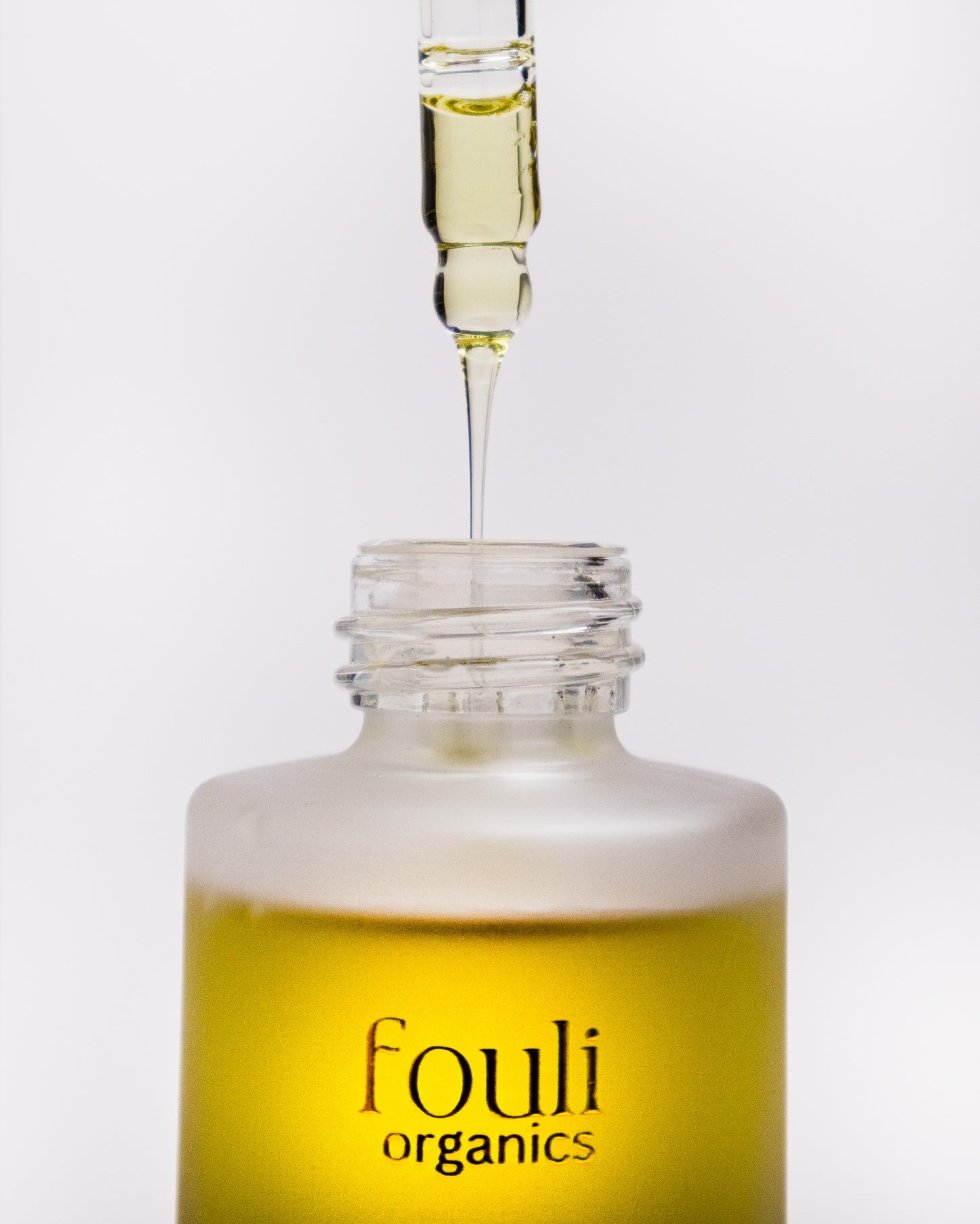 Fouli Organics dropper bottle with oil being dispensed on a white background